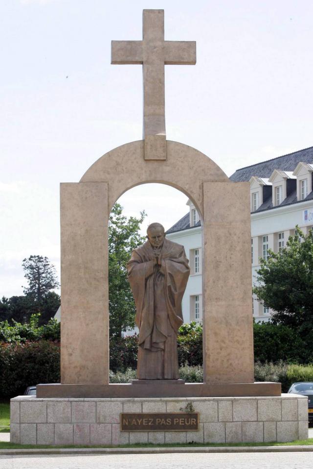 Retrait d’une croix surplombant une statue
